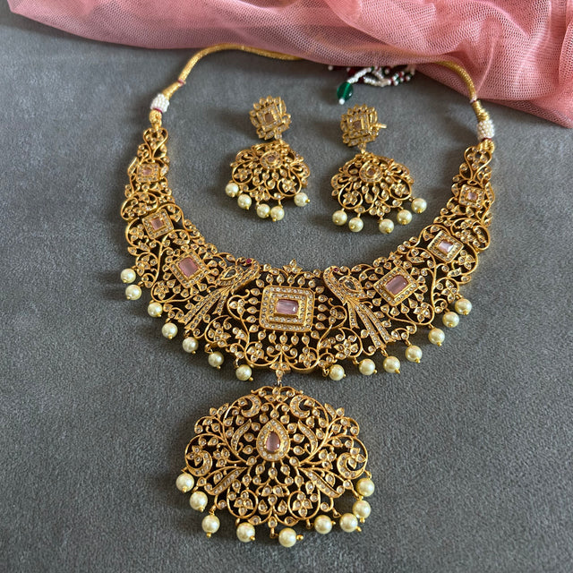 Gold necklace set with matching earrings on a gray surface IMITATION ARTIFICIAL ART FASHION JEWELLERY PINK STONES AD ANTIQUE PEACOCK DESIGN GOLD PLATED 