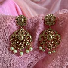 Ornate gold earrings with pearl drops on a pink fabric background Gold necklace set with matching earrings on a gray surface IMITATION ARTIFICIAL ART FASHION JEWELLERY PINK STONES AD ANTIQUE PEACOCK DESIGN GOLD PLATED 