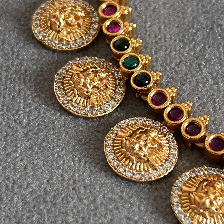 "Gold plated short necklace set with red and green kemp stones – traditional South Indian temple jewelry."