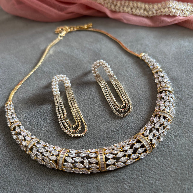Jewelry set with necklace, earrings, and bracelet on a gray surface